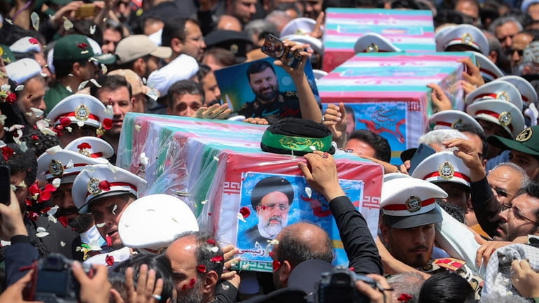 In this photo released by the Iranian Presidency Office, flag-draped...