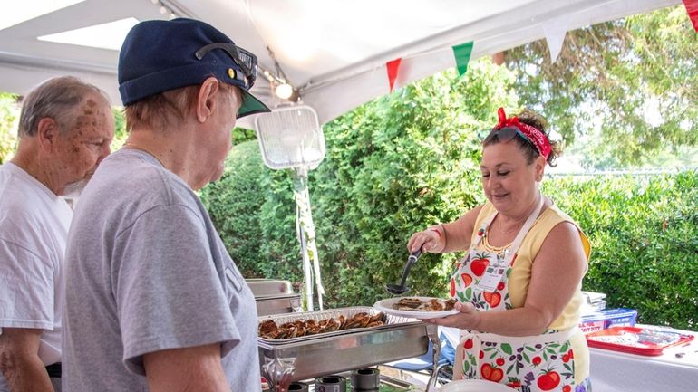 Tina Pemberton of Glen Cove serves food at the Feast of...