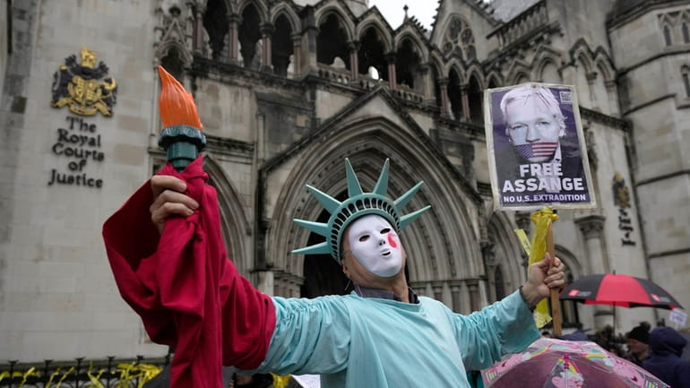 A protester stands outside the Royal Courts of Justice in...