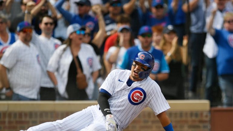 Chicago Cubs' Seiya Suzuki celebrates at home plate after scoring...