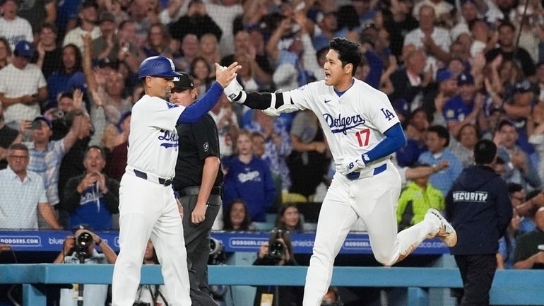 Los Angeles Dodgers designated hitter Shohei Ohtani (17) greets third...