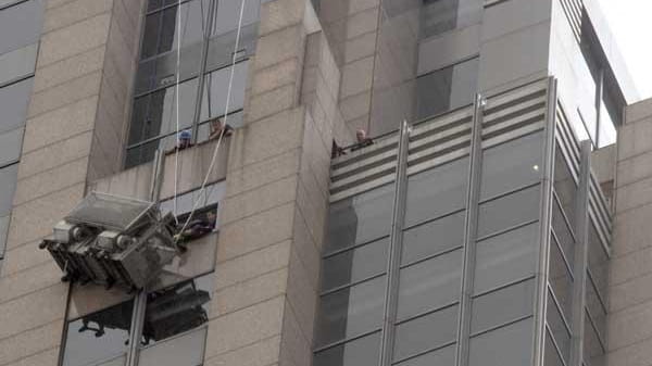 Firefighters rescue workers hanging on a scaffold in midtown. (July...