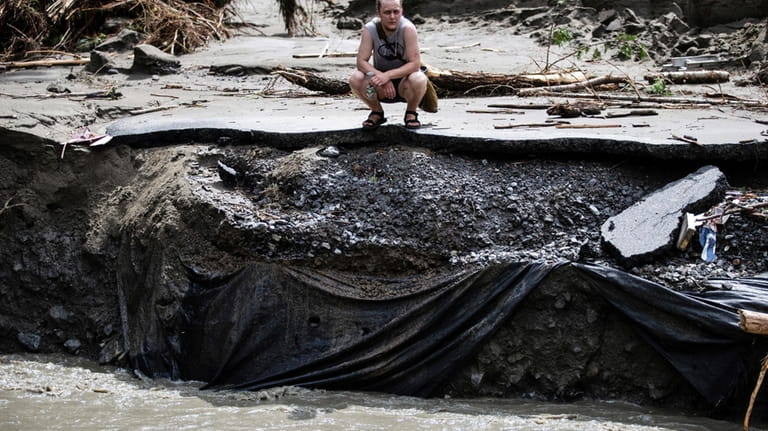 An overwhelmed residents surveys the damage following flooding caused by...