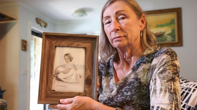 Christine Fischette at her Smithtown home with a photograph of...