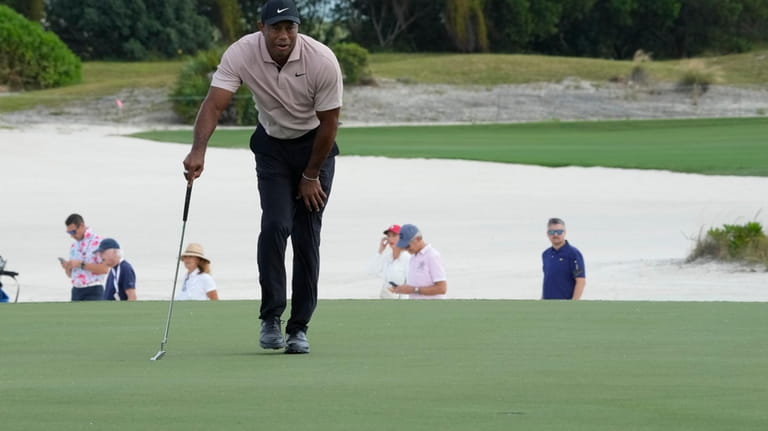 Tiger Woods studies his putt at the third green during...