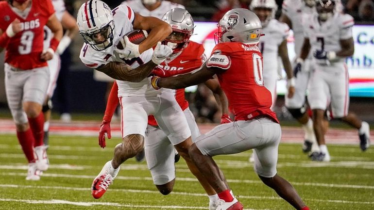 Arizona wide receiver Tetairoa McMillan (4) tries to break a...