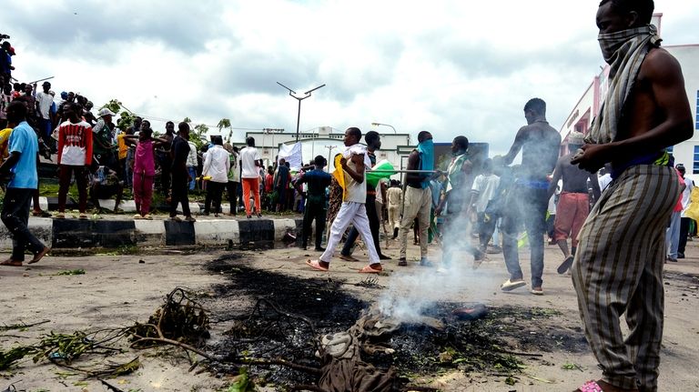 People protest on the street of Kano, Nigeria, Thursday, Aug....