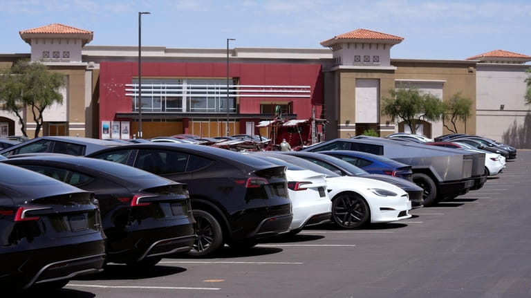 Tesla vehicles are stored at a shopping mall parking lot...
