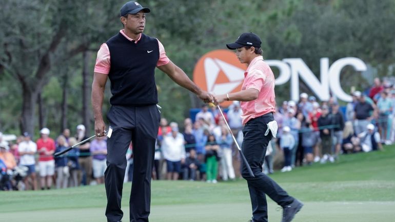 Tiger Woods, left, congratulates his son Charlie Woods, right, after...