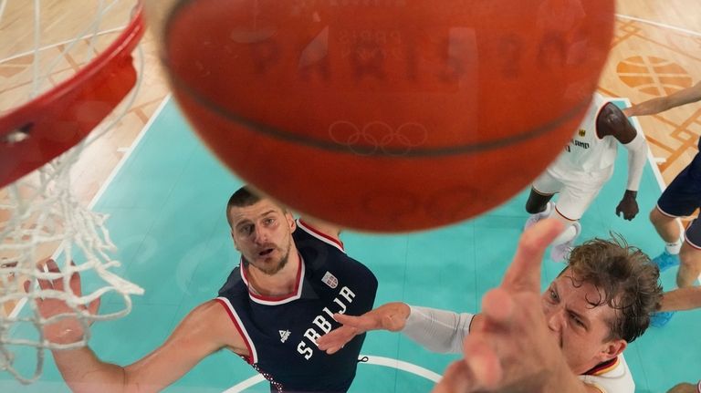 Moritz Wagner (13), of Germany shoots past Nikola Jokic (15),...