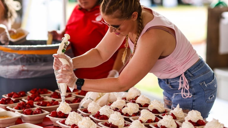 Stephanie Falisi, of Riverhead, helps make strawberry shortcacke during the...