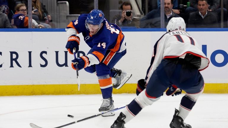 Bo Horvat #14 of the New York Islanders shoots the...