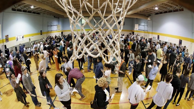 People wait to vote on Super Tuesday in the gymnasium...