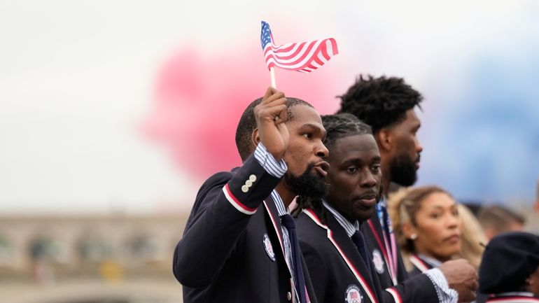 Kevin Durant, of the United States, waves a flag while...