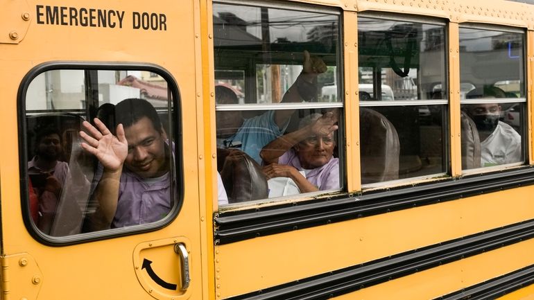 Nicaraguan citizens wave from a bus after being released from...