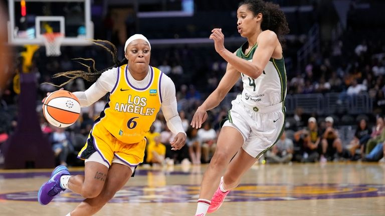 Los Angeles Sparks' Odyssey Sims, left, drives past Seattle Storm...