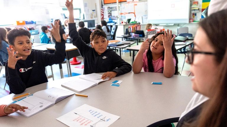 Fifth grade students attend a math lesson with teacher Alex...