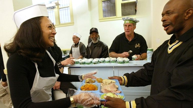 San Francisco district attorney candidate Kamala Harris, left, serves meals...