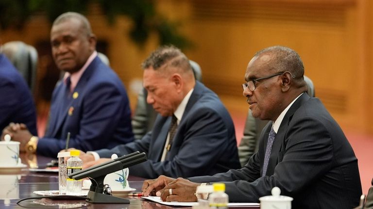 Solomon Islands’ Prime Minister Jeremiah Manele, right, with his delegation,...