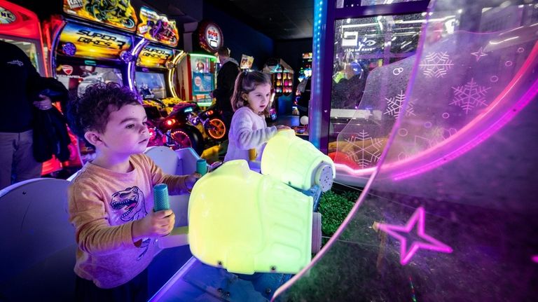 Tyler Wesselhoft, left, and Hailey Lehmann enjoy an arcade game at Ultra Lanes Bowl &...