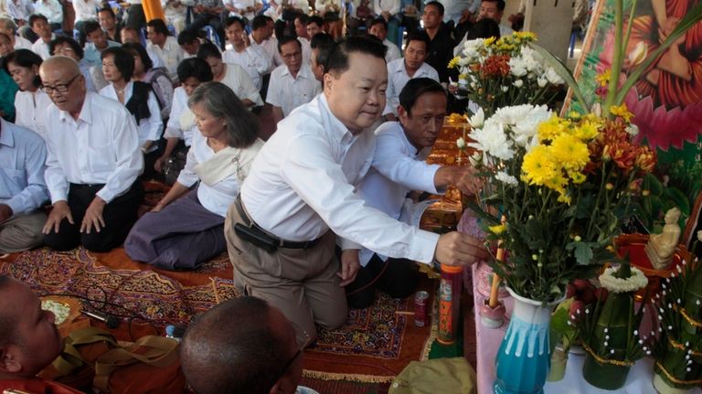 Opposition party leader Teav Vannol, burns incense sticks during a...