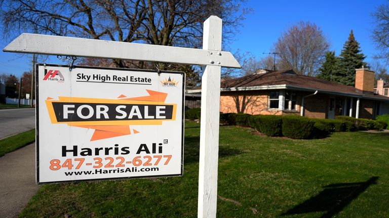 A "For Sale" sign is displayed in front of a...