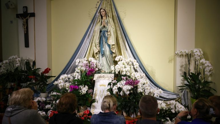 Pilgrims recited their prayers next to the statue of the...