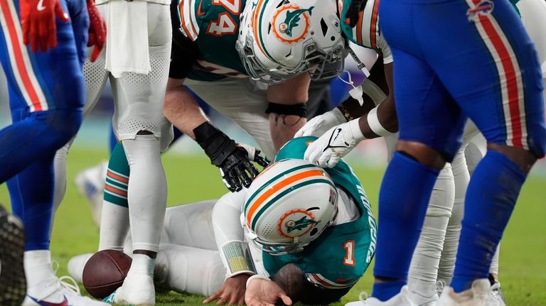 Miami Dolphins quarterback Tua Tagovailoa (1) is assisted on the...