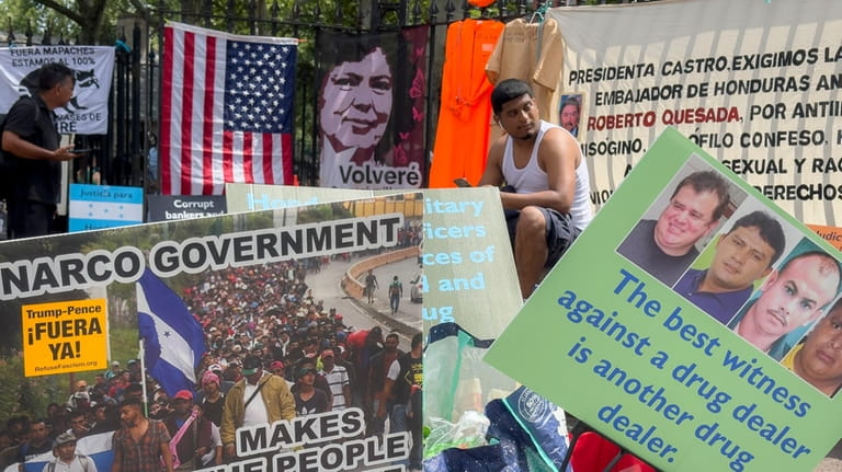 Protestors signs and images victims of Honduran drug traffickers outside...