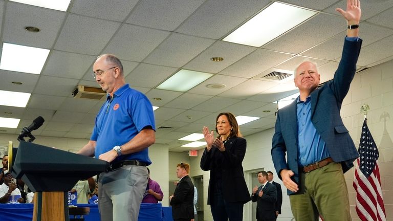 Shawn Fain, President of the United Auto Workers, left, is...