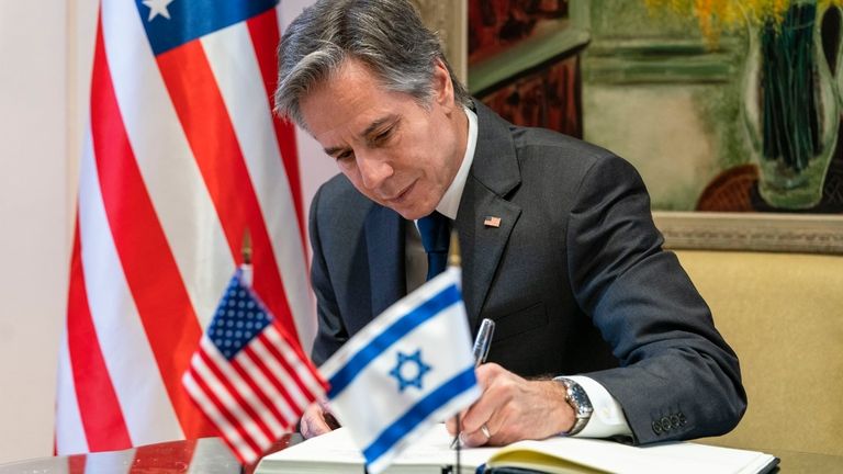 U.S. Secretary of State Antony Blinken signs a guest book...