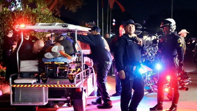 Dallas Fire-Rescue EMS loads one of the wounded onto a...