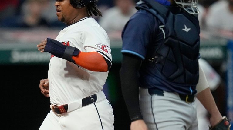 Cleveland Guardians' Jose Ramirez, left, scores behind Tampa Bay Rays...