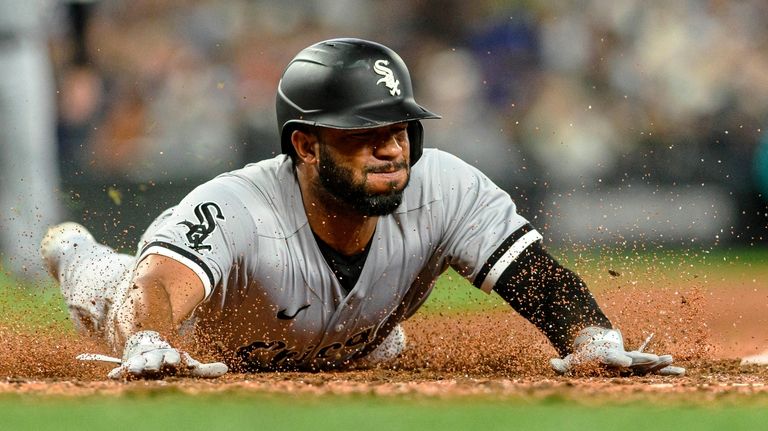 Chicago White Sox's Elvis Andrus slides home to score off...