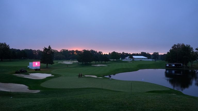 The sun rises over the 14th hold before the start...