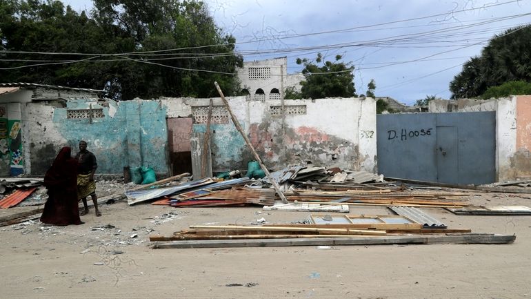 People stand on the beach following an attack in Mogadishu,...