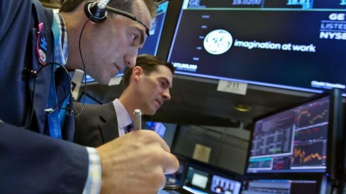 Trader Gregory Rowe, left, and specialist John McNierney work at...