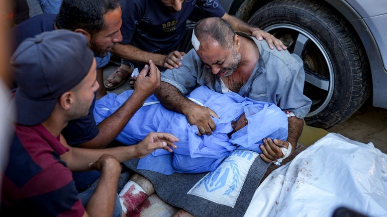 A Palestinian man mourns for a relative killed in the...