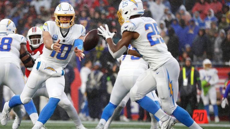 Los Angeles Chargers quarterback Justin Herbert (10) tosses the ball...