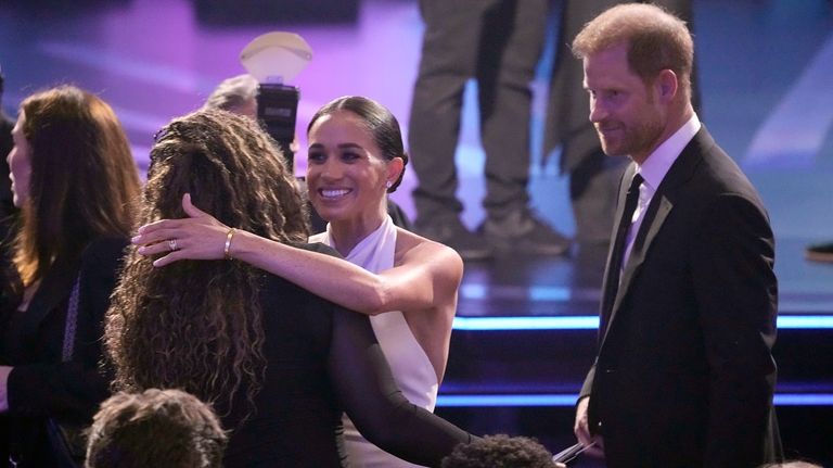 Meghan Markle, center and Prince Harry, right, arrive at the...