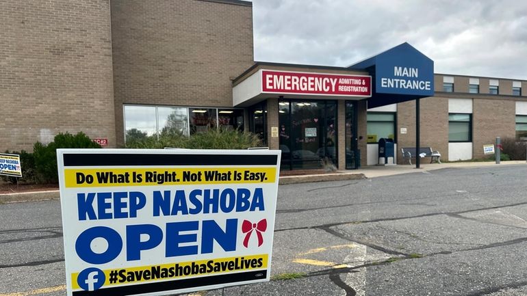 A sign pushing to keep the hospital open stands outside...