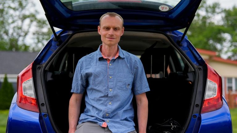 Caleb Jud, 33, poses for a portrait with his Honda...