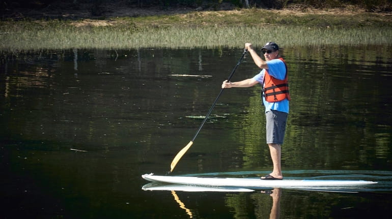 A paddler meets the stillness of Stony Brook Harbor on...