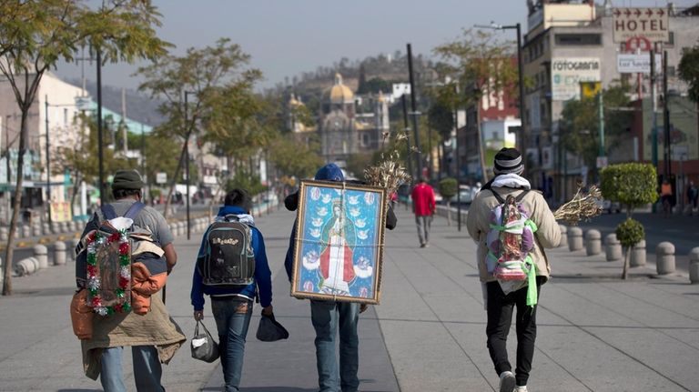 Alejandro Gonzalez carries an image of the Virgin of Guadalupe...