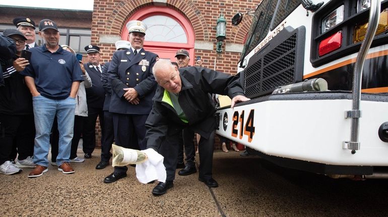 Freeport Mayor Robert Kennedy breaks a bottle of Champagne at the dedication...