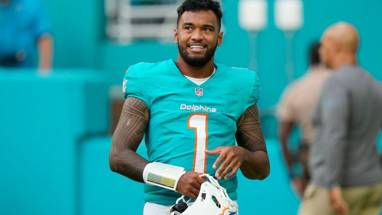 Miami Dolphins quarterback Tua Tagovailoa stands on the field before...