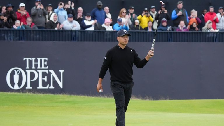 Xander Schauffele of the United States gestures to the stands...