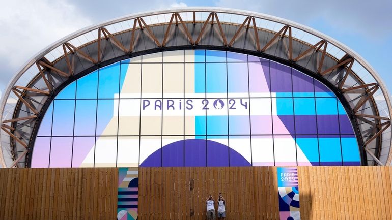 Tourists photograph near the Champ-de-Mars Arena, ahead of the 2024...