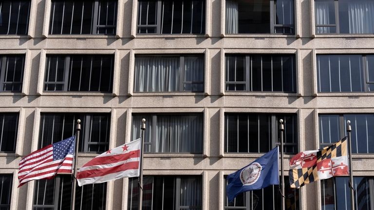 American and District of Columbia flags fly outside of the...