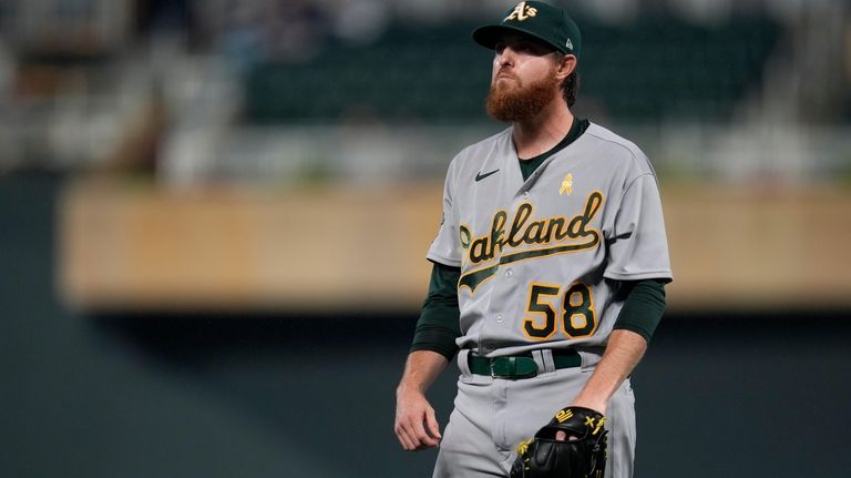 Oakland Athletics starting pitcher Paul Blackburn reacts after loading the...